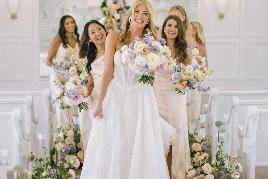 Bride walking down chapel aisle with pastel bouquet at The Nest at Ruth’s Farm